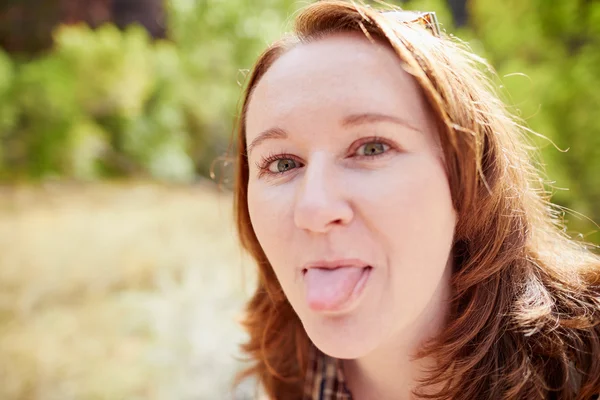 Chica sobresaliendo de su lengua — Foto de Stock