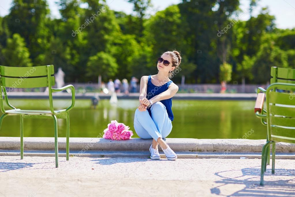 Young Parisian woman of pink peonies in Tuileries