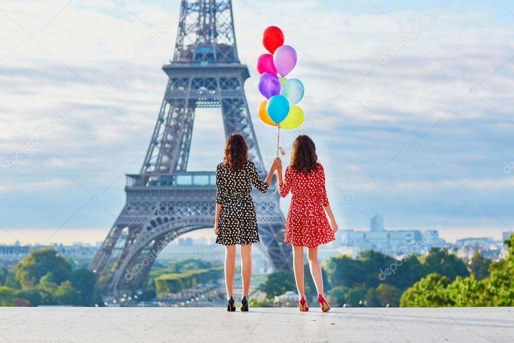 Beautiful twin sisters with colorful balloons