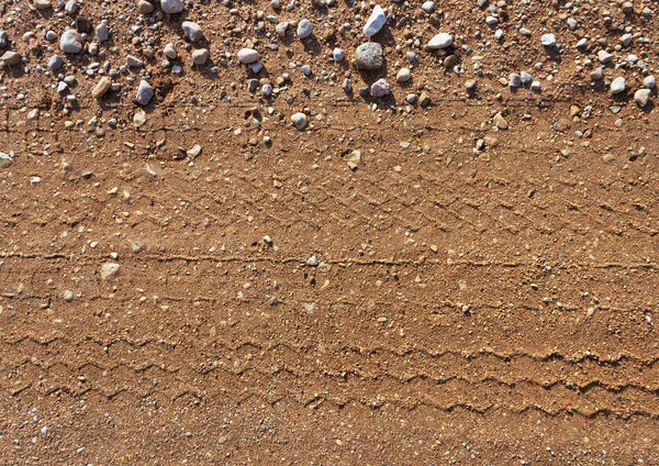 Gravel road surface with trail of wheel. — Stock Photo, Image