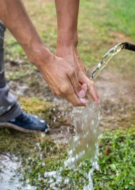 Kırsalda ellerini yıkayan bir adam..