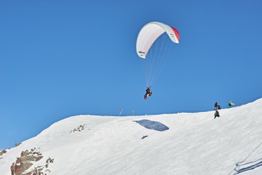  A man flying on a paraglider in the mountains clipart