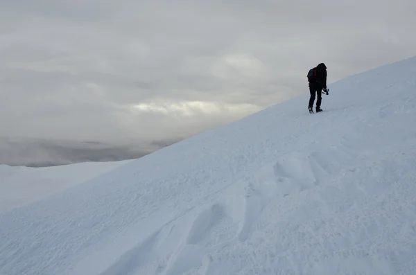 Osamělý fotograf s stativ dělat zimní turistiku na Gimba hoře během velké sněhové bouře, Zakarpatské, západní Ukrajiny — Stock fotografie
