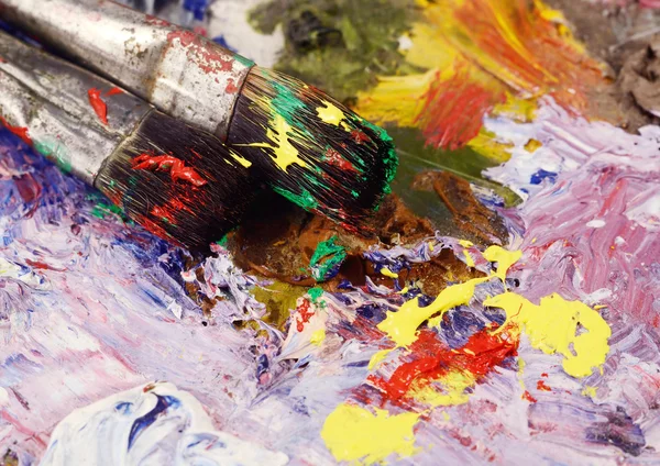 Art still life - closeup of two paintbrushes and dirty palette with colourful  oil paints,background for creative art design — Stock Photo, Image