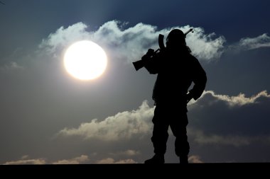 Silhouette of military soldier or officer with weapons at sunset clipart