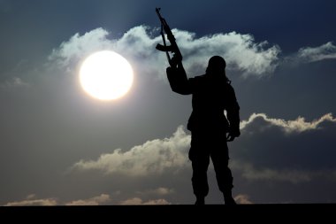 Silhouette of military soldier or officer with weapons at sunset clipart