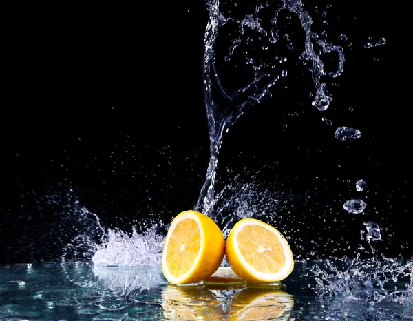 Limón en rodajas en el agua sobre fondo negro — Foto de Stock