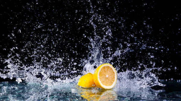黒の背景に水にレモンのスライス — ストック写真