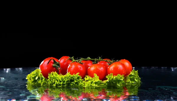 Friss paradicsom cseresznye és zöld, friss saláta víz csepp splash sötét háttér, makró csepp víz esik a piros cherry paradicsom és splash — Stock Fotó