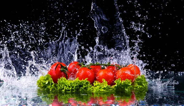 Fresh tomato cherry and green fresh salad with water drop splash on dark background Macro drops of water fall on the red cherry tomatoes and make splash — Stock Photo, Image