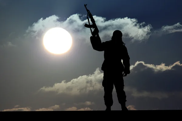 Silhouette eines Soldaten oder Offiziers mit Waffen bei Sonnenuntergang — Stockfoto