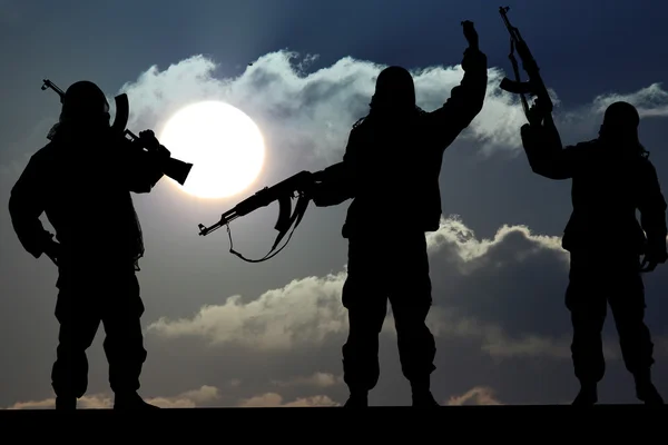 Silhouette eines Soldaten oder Offiziers mit Waffen bei Sonnenuntergang — Stockfoto