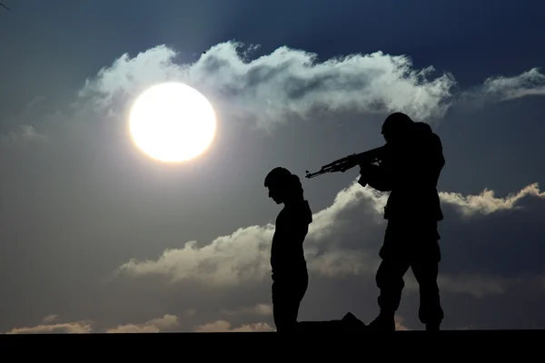 Silhouette eines Soldaten oder Offiziers mit Waffen bei Sonnenuntergang — Stockfoto