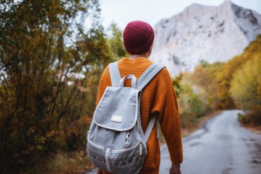 Genç ve güzel Asyalı bir hanımın dağlardaki sonbahar ormanlarında çekilmiş açık hava moda fotoğrafı. Romantik hippi kadın portresi, ılık sonbahar havası, sakin sahne. Gezgin fotoğraf serisi.