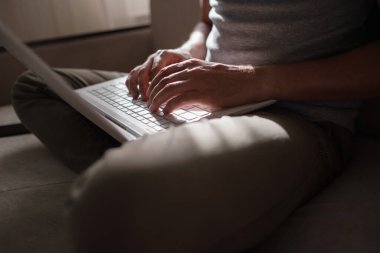 Uzaktan kumanda. Dizüstü bilgisayarda çalışan bir adam evdeki koltukta oturuyor. Metin için Boşluğu Kopyala. Serbest çalışan hipster, ortaklarıyla çalışır, çalışır ya da iletişim kurar.