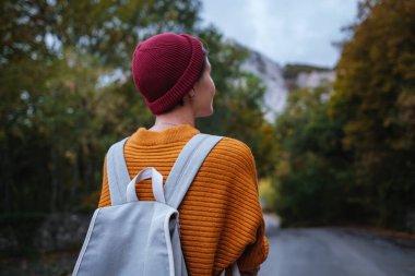 Genç ve güzel Asyalı bir hanımın dağlardaki sonbahar ormanlarında çekilmiş açık hava moda fotoğrafı. Romantik hippi kadın portresi, ılık sonbahar havası, sakin sahne. Gezgin fotoğraf serisi.