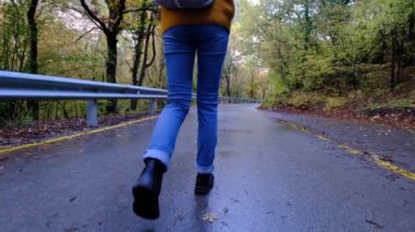 Ağır çekimde dik arazide yürüyen kadınların bacaklarını kapatın. Yürüyüş Botları Sonbahar Yolu 'nda yürüyor. Kadın ayak izleri sonbahar günü açık havada, ormanlık alanda yürüyor.