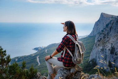woman hiker enjoy the view at mountain peak cliff. idea of ecotourism travel. Discovery Travel Destination Concept clipart