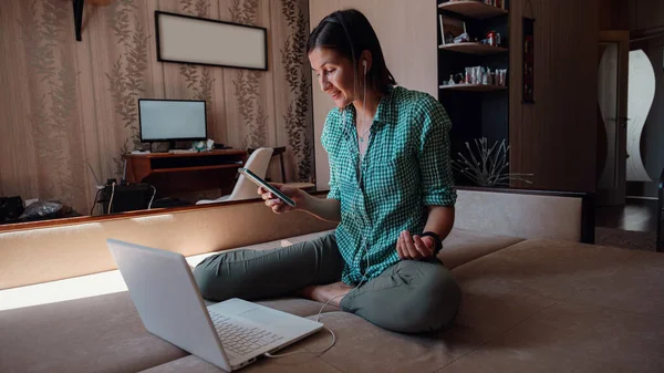 Young attractive woman on sofa working on new project with laptop in home. Attractive businesswoman studying online, using laptop software, web surfing information or shopping in internet store.