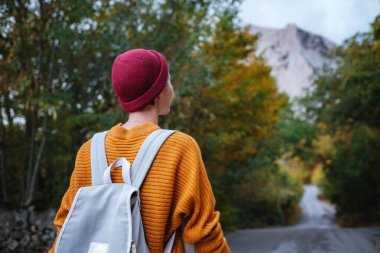 Genç ve güzel Asyalı bir hanımın dağlardaki sonbahar ormanlarında çekilmiş açık hava moda fotoğrafı. Romantik hippi kadın portresi, ılık sonbahar havası, sakin sahne. Gezgin fotoğraf serisi.