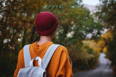 Genç ve güzel Asyalı bir hanımın dağlardaki sonbahar ormanlarında çekilmiş açık hava moda fotoğrafı. Romantik hippi kadın portresi, ılık sonbahar havası, sakin sahne. Gezgin fotoğraf serisi.