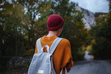 Genç ve güzel Asyalı bir hanımın dağlardaki sonbahar ormanlarında çekilmiş açık hava moda fotoğrafı. Romantik hippi kadın portresi, ılık sonbahar havası, sakin sahne. Gezgin fotoğraf serisi.