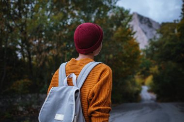 Genç ve güzel Asyalı bir hanımın dağlardaki sonbahar ormanlarında çekilmiş açık hava moda fotoğrafı. Romantik hippi kadın portresi, ılık sonbahar havası, sakin sahne. Gezgin fotoğraf serisi.