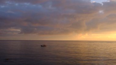 Gün batımında denizde balıkçı teknesi. Güneş altın dalgalara dalıyor. İnanılmaz deniz manzarası. Deniz manzarası, yaz ve tatil konsepti