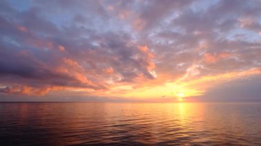 Sahilde büyülü, güzel bir gün batımı. Güneş altın dalgalara dalıyor. İnanılmaz deniz manzarası. Deniz manzarası, yaz ve tatil konsepti