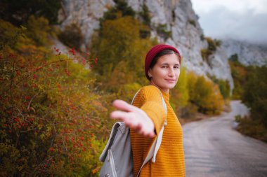 Birkaç gezgin, arka plandaki sisli dağ manzarasında el ele tutuşarak takip ediyor. Beni takip edin - POV.