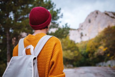 Genç ve güzel Asyalı bir hanımın dağlardaki sonbahar ormanlarında çekilmiş açık hava moda fotoğrafı. Romantik hippi kadın portresi, ılık sonbahar havası, sakin sahne. Gezgin fotoğraf serisi.
