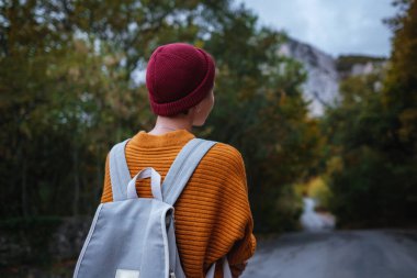 Genç ve güzel Asyalı bir hanımın dağlardaki sonbahar ormanlarında çekilmiş açık hava moda fotoğrafı. Romantik hippi kadın portresi, ılık sonbahar havası, sakin sahne. Gezgin fotoğraf serisi.