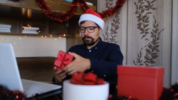 Man Met Kerstmuts Die Het Kerstcadeau Opent Walgelijk Uitziet Zittend — Stockvideo