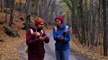 Sırt çantalı hippi yürüyüşçüler ormanda kayboldular, akıllı telefon uygulamalarına bakıyorlardı.