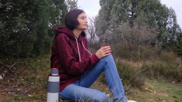 Viajero mujer bebe té termo en el fondo de la naturaleza — Vídeo de stock