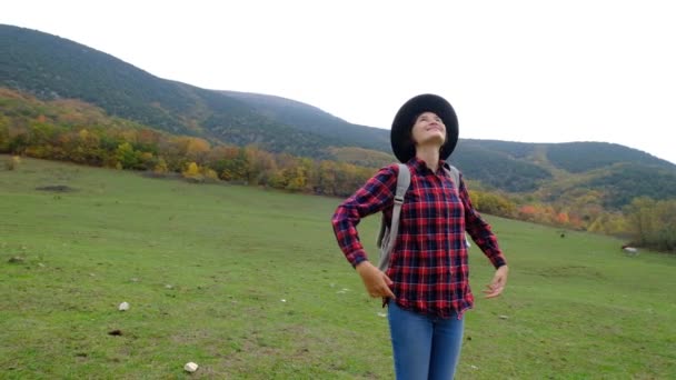 Mooie aziatische vrouw in geruite shirt en hoed op de achtergrond van de herfst bos . — Stockvideo