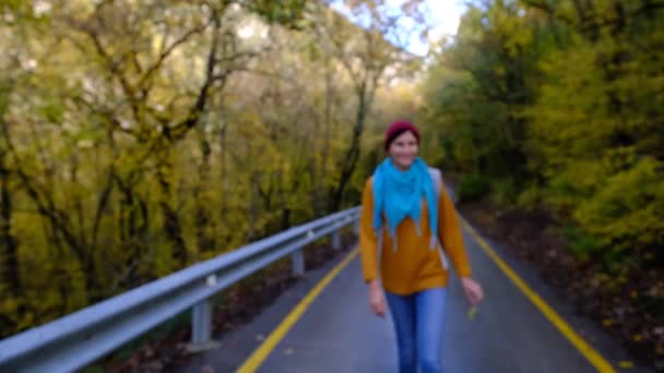 Jonge vrouw wandelen in het bos in de herfst. — Stockvideo