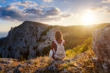 Kadın yürüyüşçü, Sunset Mountain Peak Cliff 'in manzarasının tadını çıkarıyor. Eko-turizm seyahati. Keşif Seyahat Hedefi Konsepti