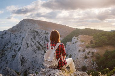 Kadın yürüyüşçü, Sunset Mountain Peak Cliff 'in manzarasının tadını çıkarıyor. Eko-turizm seyahati. Keşif Seyahat Hedefi Konsepti