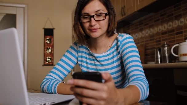 Молодая азиатка, сидящая за столом, работает в Интернете или учится. — стоковое видео