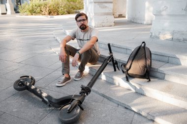 Sokakta elektrikli scooter 'ı olan genç bir adam kazası. Şehir caddesinde bir adam scooter 'dan düştü..