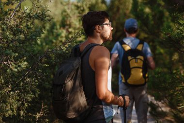 Yürüyüş yapan iki adam dağda yürüyüşe çıkar. Dağlarda dolaşmak. Spor turizminde tepeler ve tepeler. Maceranın tadını. Arka planda yürüyüşçü.