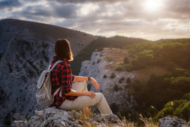 Kadın yürüyüşçü, Sunset Mountain Peak Cliff 'in manzarasının tadını çıkarıyor. Eko-turizm seyahati. Keşif Seyahat Hedefi Konsepti