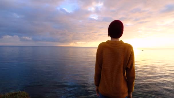 Mujer joven que se relaja meditando sola en la playa del mar en el colorido fondo del cielo. Estrés superado — Vídeo de stock