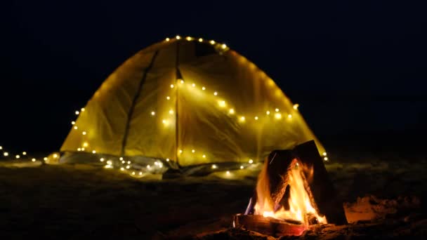 キャンプ場のたき火テントや海を背景にキャンプ場でキャンプファイヤー. — ストック動画