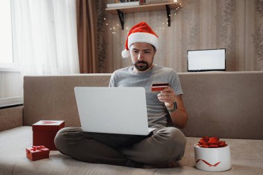 Noel alışverişi, satış ve indirimler Noel tatilleri boyunca, online alışveriş ve koronavirüs kilitlenmesi. İnternetten Noel hediyesi alan bir adam.