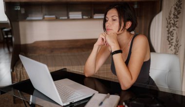 Düşünceli Asyalı bayan öğrenci düşünme sorununu görmezden geliyor işte yaratıcı fikirlerin eksikliğini hissediyor düşünceli, kafası karışmış ya da sıkılmış genç bir kadın dizüstü bilgisayarla masada oturuyor.