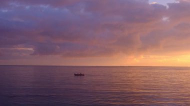 Sahilde büyülü, güzel bir gün batımı. Güneş altın dalgalara dalıyor.