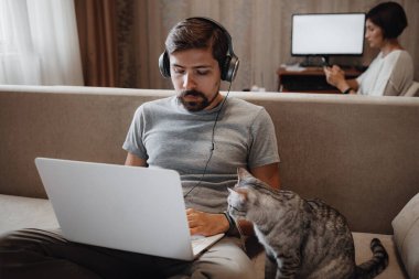 Evde çalışan ve bilgisayarla oynayan çift..
