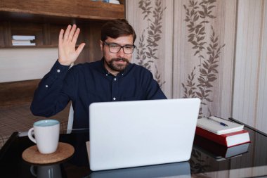 Masada oturmuş Webinar video kursunu izleyen odaklanmış bir adam online uygulama web sitesinde yeni bilgiler ediniyor. Yönetici ile konuşmak profesyonel yardım ve destek kavramı sağlar